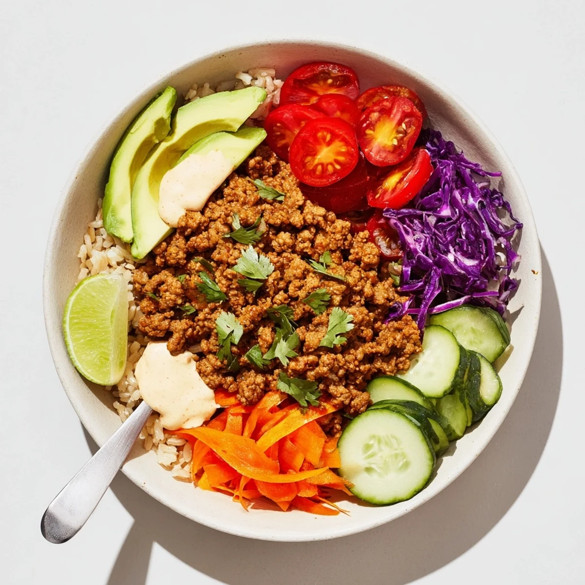 Savory Plant-Based Meat Bowl, drizzled with spicy mayo and garnished with cilantro.