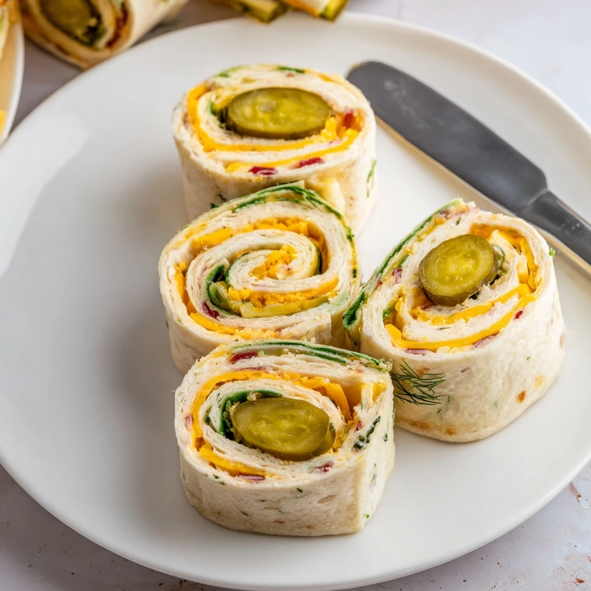 Colorful rolls of pickle-in-a-blanket, drizzled with mustard and fresh herbs.
