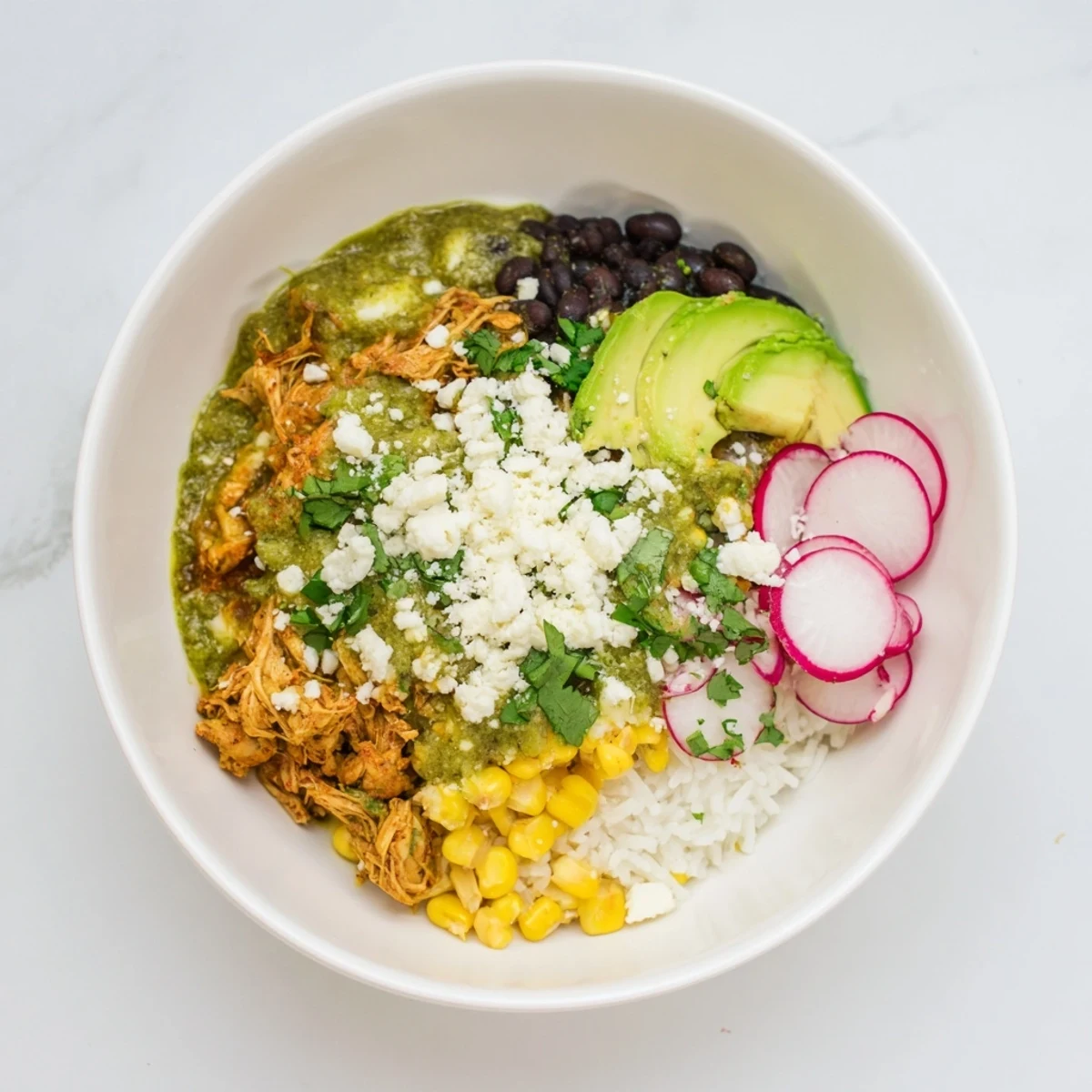 Warm Green Enchiladas Rice Bowl, showcasing fluffy rice topped with flavorful chicken and cheese, ready to eat.