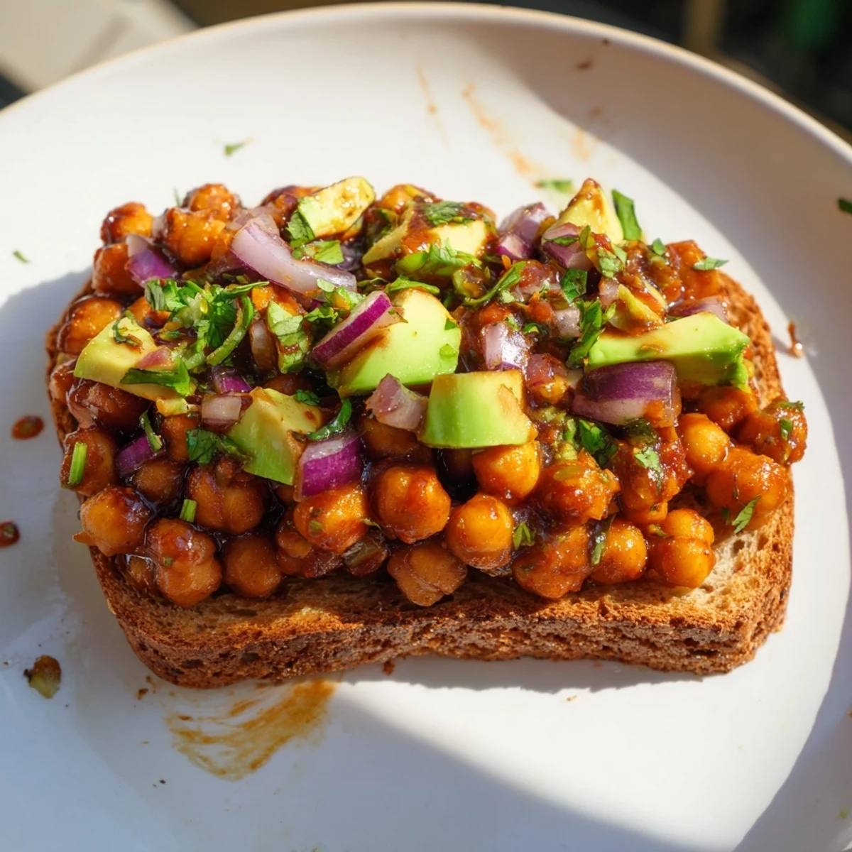 Golden, toasted bread piled high with juicy, glistening BBQ Chickpeas, ready to eat.