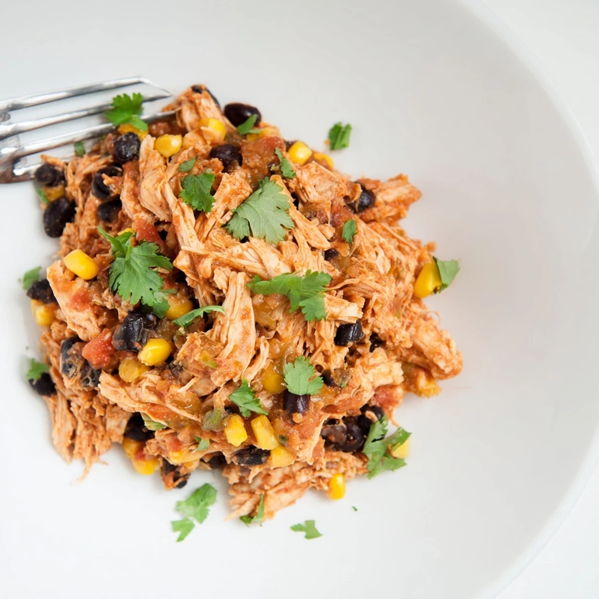 Close-up shot shows tender Slow Cooker Salsa Chicken, ideal for a quick and easy weeknight dinner.