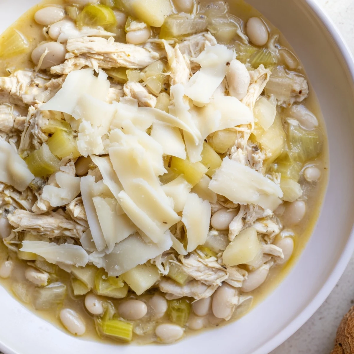 Steaming bowl of 35-Minute White Cheddar Apple Chicken Chili, topped with creamy melted cheese.