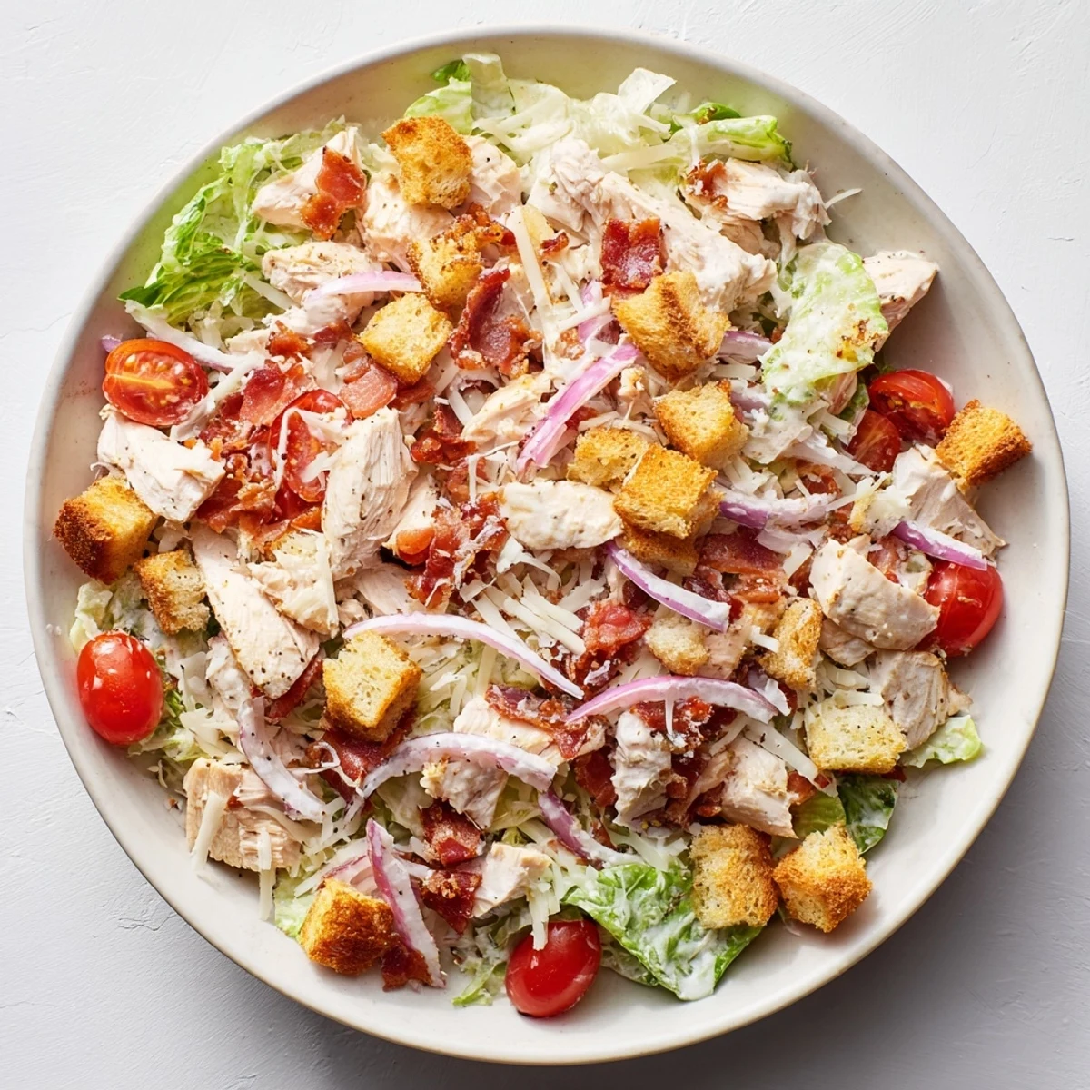 Costco Chicken Bake Salad Bowl with tender chicken, crispy bacon, and creamy Caesar dressing, ready to enjoy.