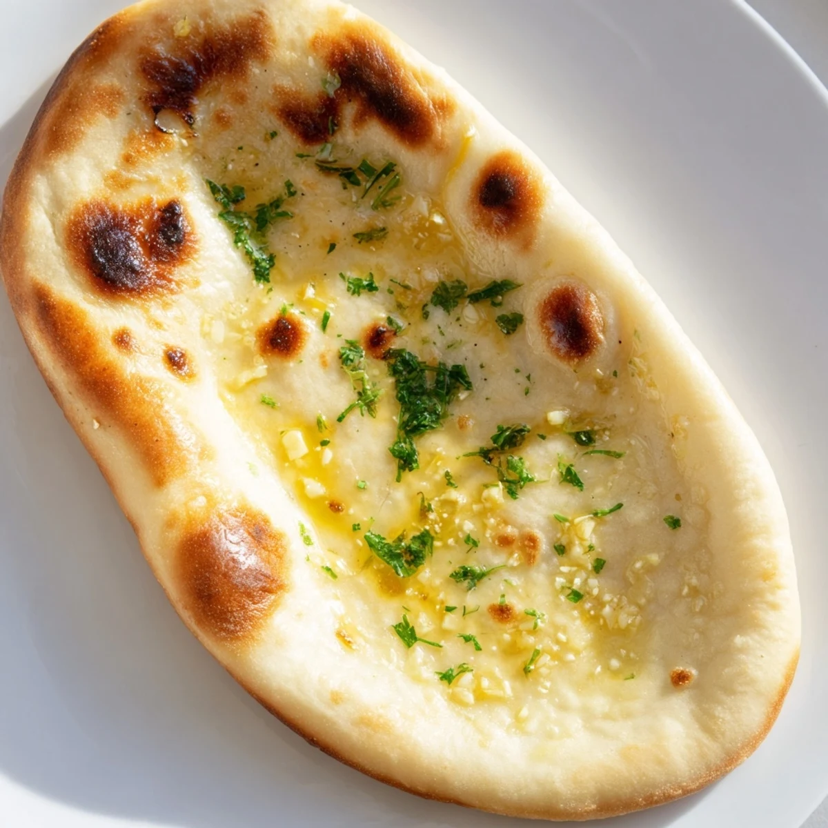 Freshly baked Homemade Garlic Naan, soft and pillowy, perfect for scooping up delicious curry.
