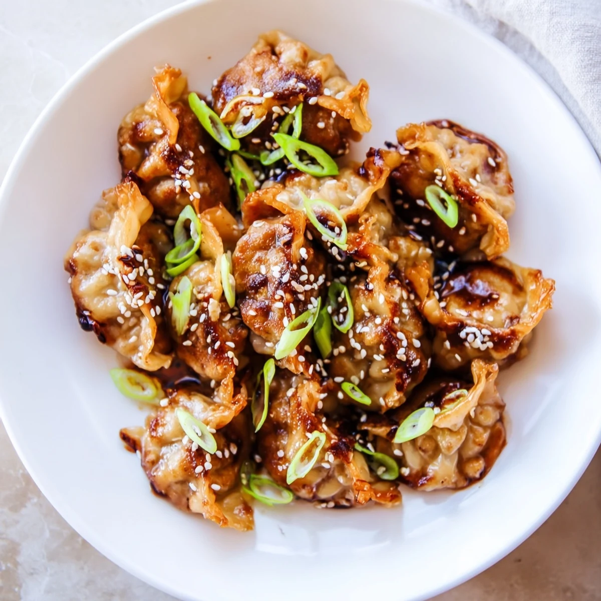 Crispy air fryer frozen dumplings glistening in a sesame oil glaze, ready to serve and enjoy.