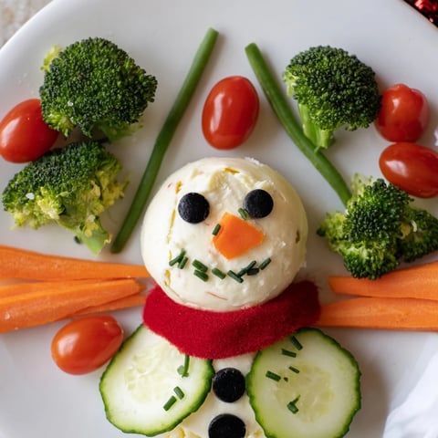 Creamy Snowman Veggie Dip Platter featuring a fun snowman encircled by fresh, vibrant vegetables.