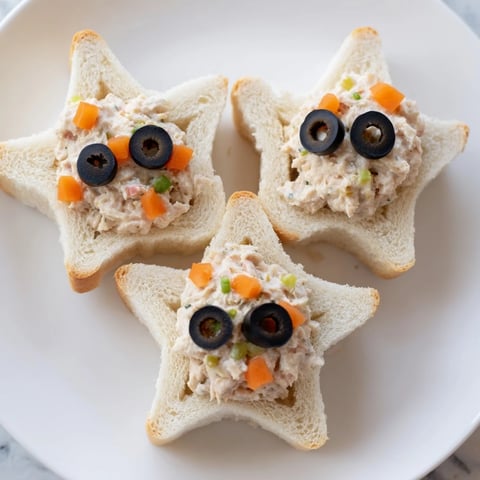 Golden mini starfish sandwiches filled with tuna, garnished with olive eyes, ready to serve and enjoy.
