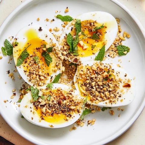 Golden, perfectly cooked Dukkah-Spiced Eggs, showcasing a vibrant display of fresh herbs and toasted spices.