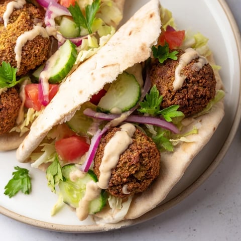 Golden, crispy falafel pita pocket bursting with fresh, vibrant vegetables and creamy tahini.