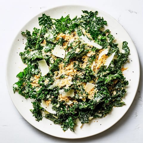 Vibrant massaged kale tossed in a creamy garlic-Parmesan dressing, topped with golden toasted breadcrumbs for a savory, crunchy finish.  