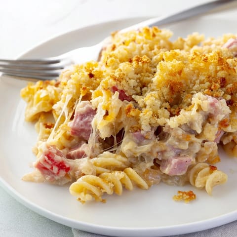 Creamy Stringy Ham Casserole: a close-up view of cheesy noodles and savory ham chunks.