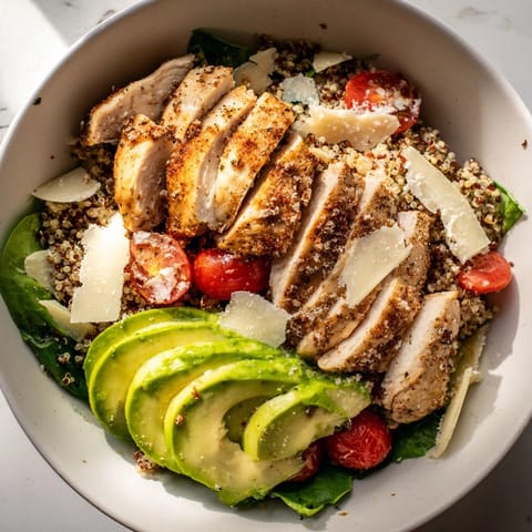 Deconstructed Avocado Chicken Caesar Grain Bowl showcasing textures of grains, avocado, and dressing.
