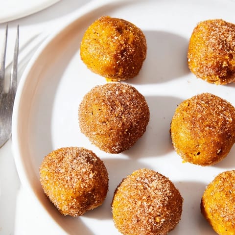 Golden pumpkin muffin balls topped with cinnamon sugar, perfect for breakfast treats.  
