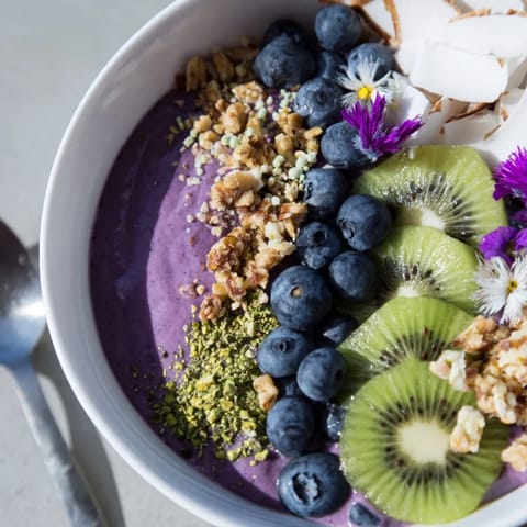 Colorful smoothie bowls topped with pistachios and berries, perfect for breakfast delights.  