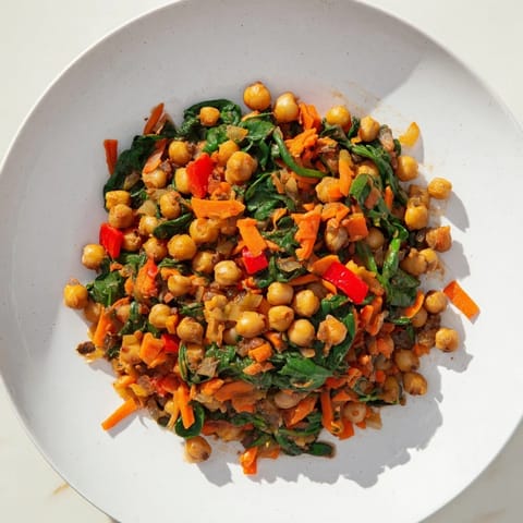 A colorful Vegetarian Chickpea & Spinach Skillet, served with crusty bread, ready for a delicious meal.