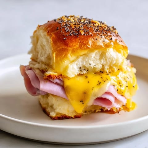 Warm, cheesy, and irresistible Baked Ham and Cheese Party Sliders fresh from the oven, ready to serve.