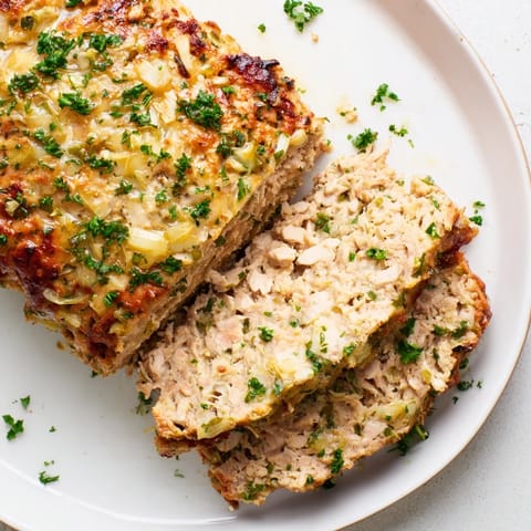 Warm plate of Juicy Garlic Parmesan Chicken Meatloaf, juicy and flavorful after baking, ready to serve with sides.