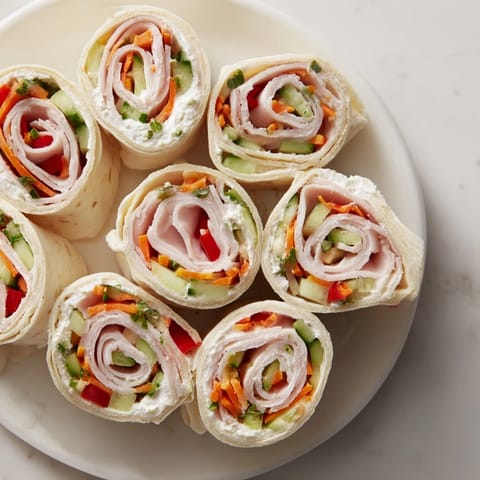 Vibrant holiday image: a Smoked Turkey Pinwheels Tree appetizer with parsley, tomatoes, and a yellow pepper star.