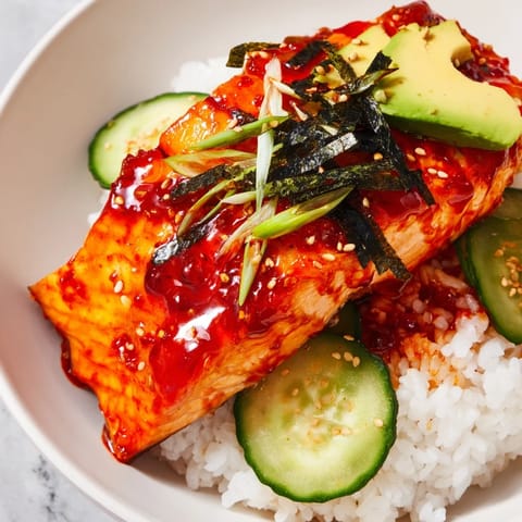 This vibrant Emily Mariko-Inspired Salmon Bowl features sticky, flavorful salmon on fluffy rice and nori.