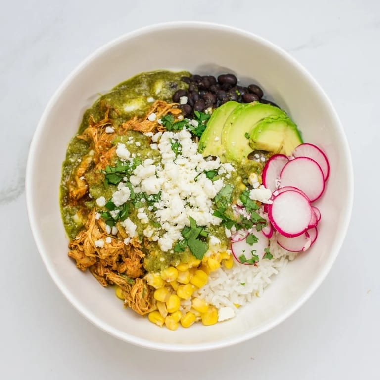 Warm Green Enchiladas Rice Bowl, showcasing fluffy rice topped with flavorful chicken and cheese, ready to eat.