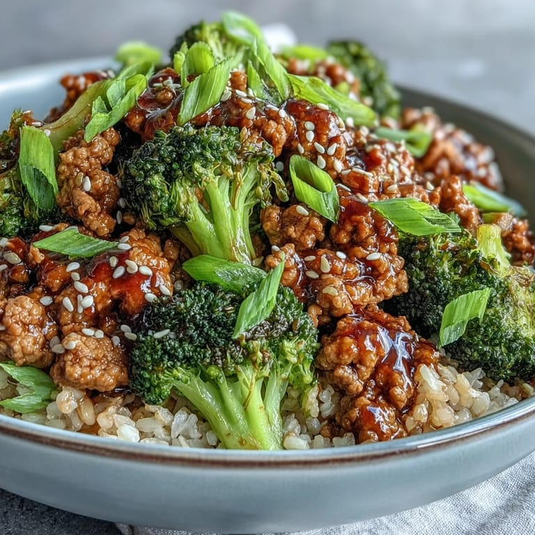 A close-up shows fluffy brown rice topped with saucy turkey and bright green broccoli florets for a healthy, dairy-free weeknight meal.